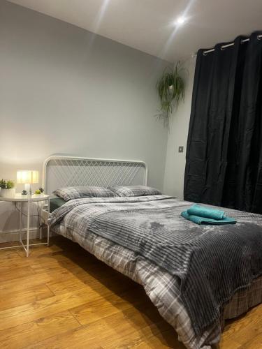 Un dormitorio con una cama y una mesa con una planta en Vf apartments kingsbury, en The Hyde