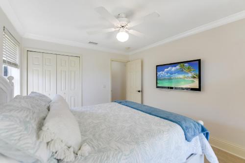 a white bedroom with a bed and a ceiling fan at Turtle Caye in Sanibel