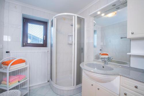 a white bathroom with a shower and a sink at Landhaus Vier Jahreszeiten in Krimml