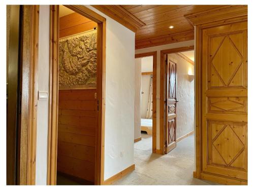 - un couloir avec des portes en bois dans une maison dans l'établissement Appartement lumineux Courchevel - 6 pers, 3 ch, parking, près des pistes - FR-1-514-88, à Courchevel