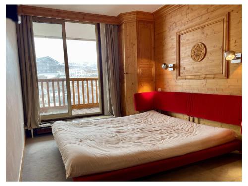 un lit dans une chambre avec une grande fenêtre dans l'établissement Appartement lumineux Courchevel - 6 pers, 3 ch, parking, près des pistes - FR-1-514-88, à Courchevel