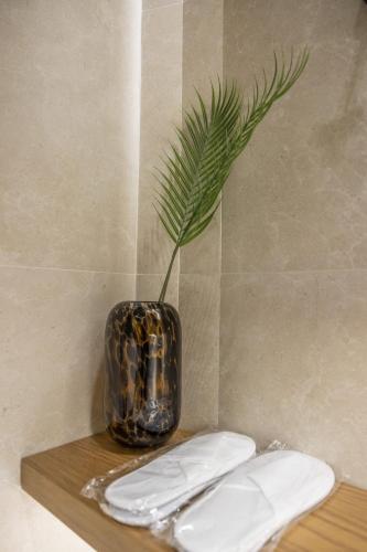 Eine Vase mit einer Pflanze auf einem Regal in der Unterkunft Polyzos Luxury Suites Meteora #7 - Adults Friendly in Kalambaka
