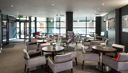a restaurant with tables and chairs and windows at ibis Glasgow City Centre – Sauchiehall St in Glasgow