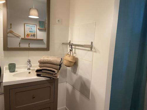 a bathroom with a sink and a mirror at La Bohème ô coeur du centre ville in Les Herbiers