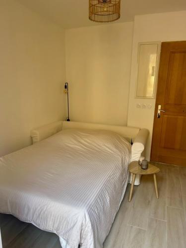 une chambre avec un lit blanc et une table dans l'établissement Appartement proche de la vieille ville Nice et promenade des anglais, à Nice