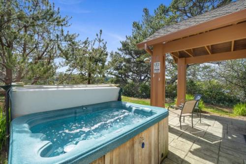 a hot tub on a patio with a gazebo at Lakefront Retreat Hot Tub & Semi-Private Dock in Rockaway Beach