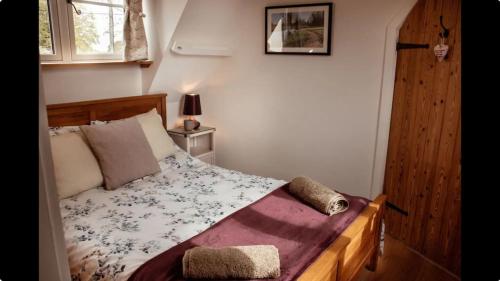 a bedroom with a bed and a window at Little Owl Lodge in Hainford