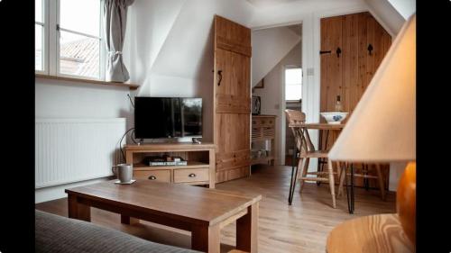 a living room with a tv and a coffee table at Little Owl Lodge in Hainford