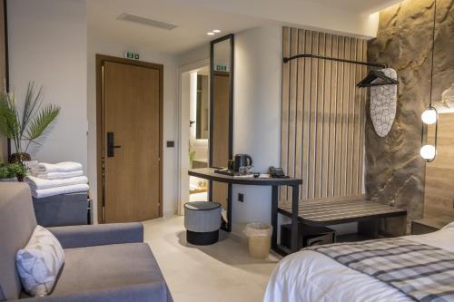 a bedroom with a bed and a desk in a room at Polyzos Luxury Suites Meteora #8 - Adults Friendly in Kalabaka