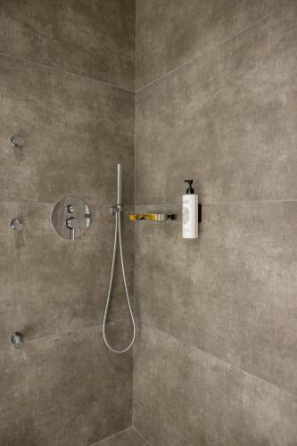 a bathroom with a shower with a hose in it at Polyzos Luxury Suites Meteora #8 - Adults Friendly in Kalabaka