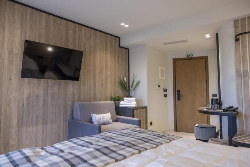 a bedroom with a bed and a tv on a wall at Polyzos Luxury Suites Meteora #8 - Adults Friendly in Kalabaka