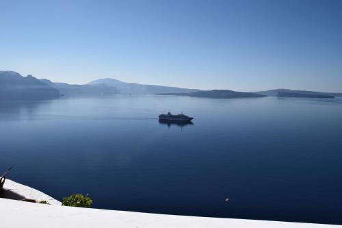 a boat in the middle of a large body of water at Helianthus Dream Homes in Oia