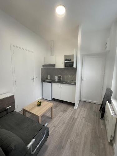 Cette chambre comprend un lit, une table et une cuisine. dans l'établissement Lune Argentée - RDC - Centre ville, à Clermont-Ferrand