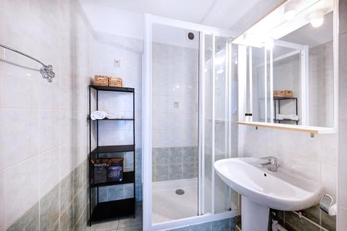 une salle de bain blanche avec un lavabo et une douche dans l'établissement Charmant T3 au Cœur de Lyon 7ème, à Lyon