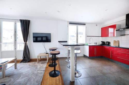 - une cuisine avec des placards rouges et une table dans une pièce dans l'établissement Charmant T3 au Cœur de Lyon 7ème, à Lyon