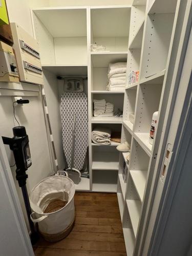 - un dressing avec des étagères blanches et un seau dans l'établissement Magnifique 2 pièces rénové à neuf, Paris 15, Idéalement situé, à Paris