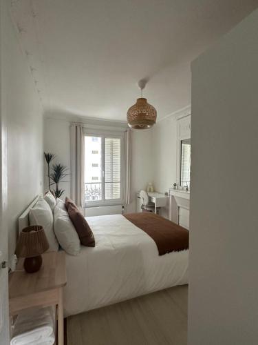 une chambre avec un grand lit blanc et un bureau dans l'établissement Magnifique 2 pièces rénové à neuf, Paris 15, Idéalement situé, à Paris