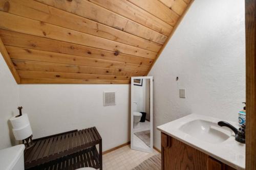 a bathroom with a sink and a wooden ceiling at Charming Beach Cabin Close Beach Access in Rockaway Beach