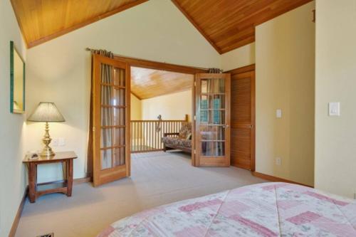 ein Schlafzimmer mit einem Bett und einem Balkon in der Unterkunft Family Getaway 3 Br Walk To Beach Jacuzzi Tub in Rockaway Beach