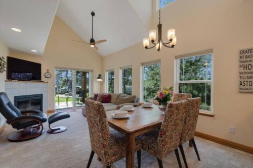 a dining room with a table and chairs and a couch at Lakefront Retreat Hot Tub & Semi-Private Dock in Rockaway Beach