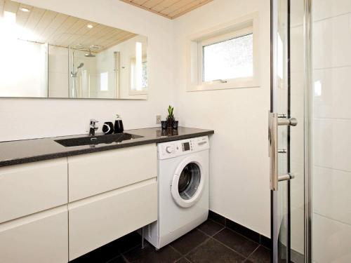 a white laundry room with a washer and dryer at 6 person holiday home in Hjørring in Lønstrup