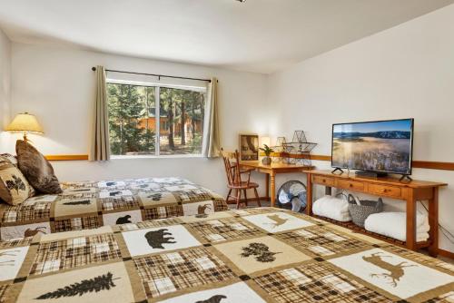 a bedroom with two beds and a desk and a television at Relaxing Four Bears Cabin in Big Bear Lake in Big Bear Lake