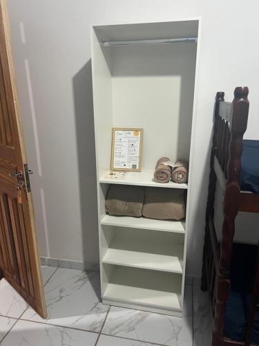 a walk in closet with shelves in a room at Quarto Recanto Monte Trigo in São Francisco do Sul