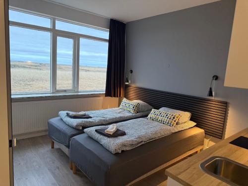 a bedroom with a bed with a sink and a window at Ocean Breeze Apartments in Selfoss