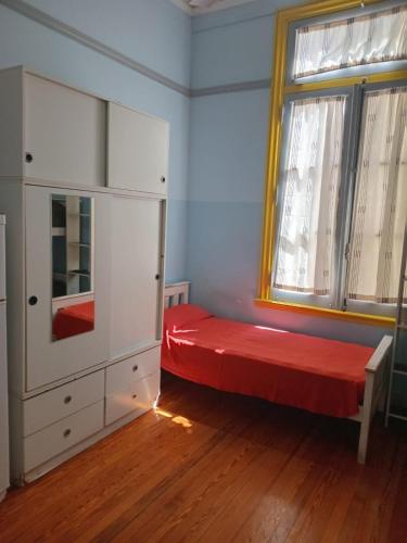 a bedroom with a red bed and a window at Tinta Roja Residencia Estudiantil in Buenos Aires