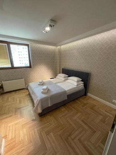 a bedroom with a bed and a window at President Apartments by WarsawResidence Group in Warsaw