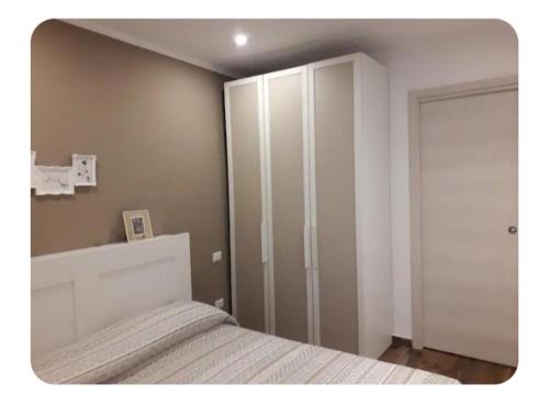 a bedroom with a white bed and a closet at Casa Mangiafuoco in Vernante