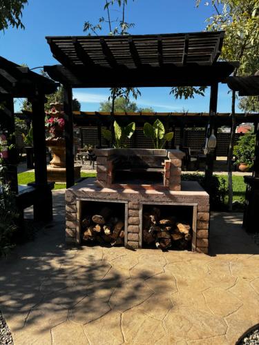 a brick fire pit in a yard with a pergola at Estancita Elena in Valle de Guadalupe