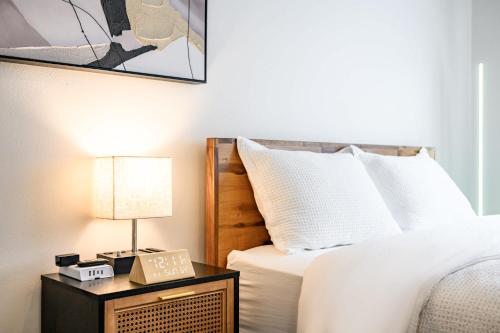 ein Schlafzimmer mit einem Bett und einem Tisch mit einer Lampe in der Unterkunft Modern Cozy Retreat Stylish Stay with Patio & Parking in Monterey Park