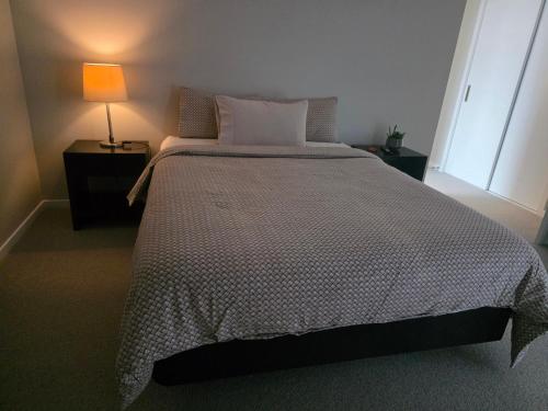 een slaapkamer met een groot bed met een lamp erop bij Loop the Loop in Queenstown