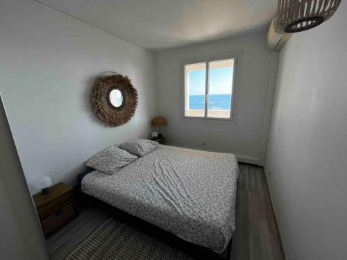 a bedroom with a bed and a mirror on the wall at Beautiful beachfront apartment in Carry-le-Rouet