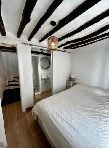a bedroom with a white bed and a ceiling at Casa María Lanjarón in Lanjarón