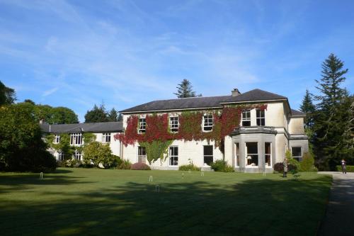 a large white house with red ivy on it at Currarevagh House in Oughterard