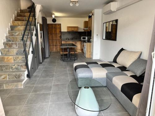 un salon avec un canapé et un escalier dans l'établissement Maison avec cour 8 personnes - Bazarette, à Saintes-Maries-de-la-Mer