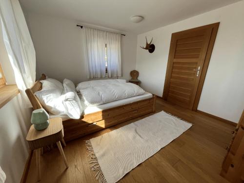 a bedroom with a bed with white sheets and a window at Chalet mit Bergblick & Sauna in Pill