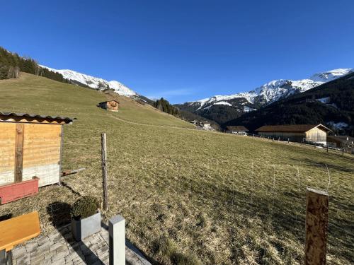 a grassy field with a house and mountains in the background at Chalet mit Bergblick & Sauna in Pill
