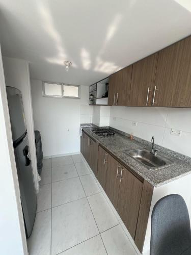 a small kitchen with a sink and a refrigerator at Apartamento Mirador del Valle in Valledupar