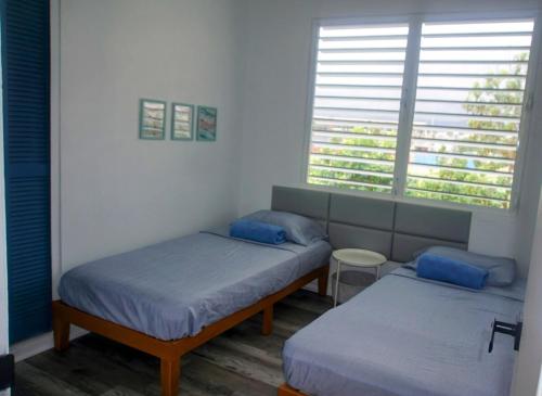 a bedroom with two beds and a window at Best Beach in PR! Beachfront 6 Bedr & Food Forest in Luquillo