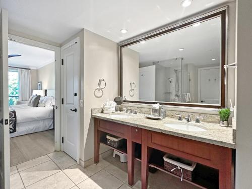 a bathroom with a sink and a large mirror at Konea 244 at Honua Kai in Lahaina