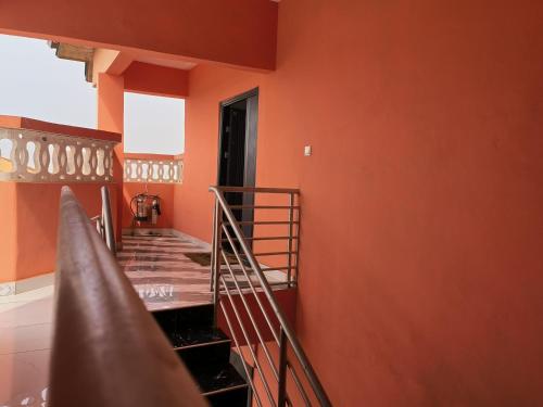 a staircase in a room with orange walls at Empress White House Accra in Tema