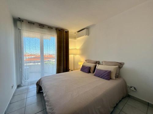 une chambre avec un grand lit avec une fenêtre dans l'établissement Elegant Apartment with Private Pool, Parking & 5min to beach, à Antibes