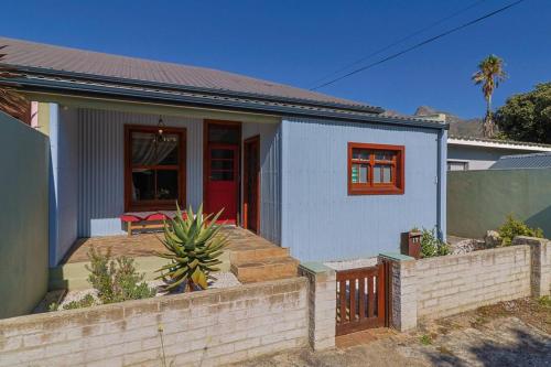 a small white house with a fence in front of it at Bietjie Sjiek - cozy stay, big breakaway in Kleinmond