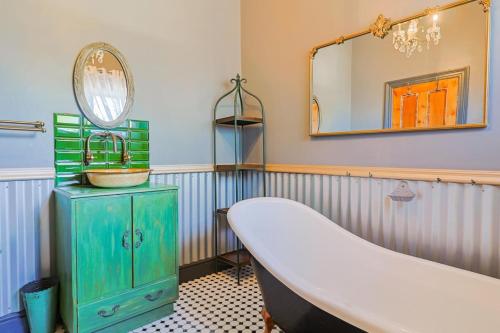 a bathroom with a tub and a sink and a mirror at Bietjie Sjiek - cozy stay, big breakaway in Kleinmond