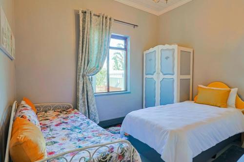 a bedroom with two beds and a window at Bietjie Sjiek - cozy stay, big breakaway in Kleinmond