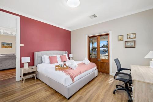 a bedroom with a bed and a red wall at Seaside Escape in North Arm Cove