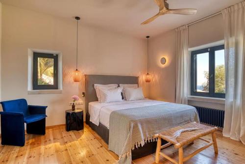 a bedroom with a bed and a blue chair at Villa Hestia - Full estate in Kóstos